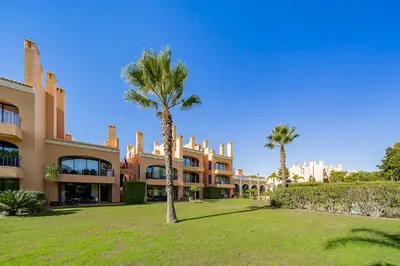 a palm tree in front of a building at AL - Apartamentos Vila Sol F5 Bloco 3 in Quarteira