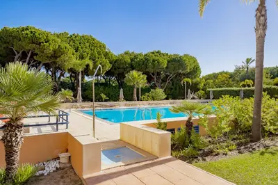 a swimming pool in a resort with a palm tree at AL - Apartamentos Vila Sol F5 Bloco 3 in Quarteira