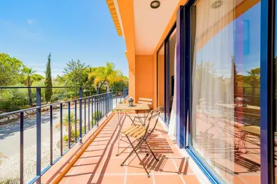 a balcony with chairs and a table on it at AL - Apartamentos Vila Sol F5 Bloco 3 in Quarteira