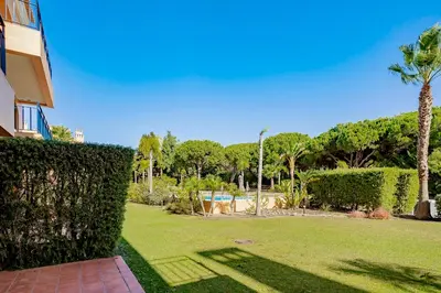 a hedge in front of a yard with a swimming pool at AL - Apartamentos Vila Sol F5 Bloco 3 in Quarteira