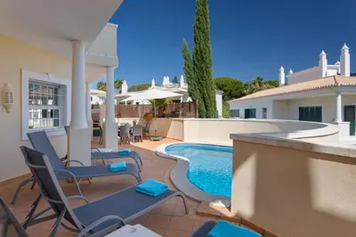 a patio with chairs and a swimming pool at Aleisha in Vale do Lobo