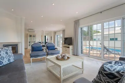 a living room with a couch and a table and a tv at Aleisha in Vale do Lobo