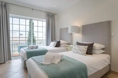 a hotel room with two beds and a large window at Aleisha in Vale do Lobo