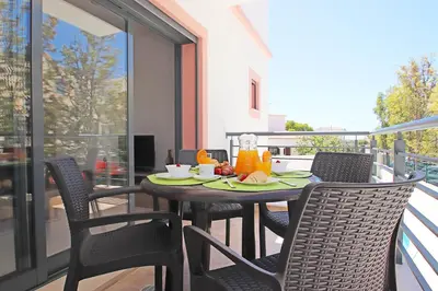 a table and chairs on a balcony with food on it at Apartment Caracas 1 by Algarve Vacation in Albufeira