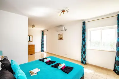 a living room with a blue bed and a couch at Villa Saint Martin by Algarve Vacation in Albufeira
