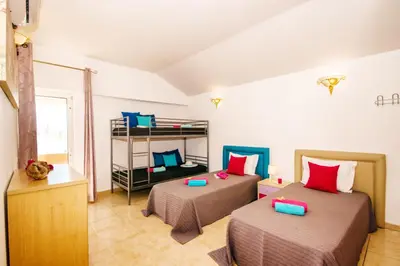 a bedroom with two beds and a book shelf at Villa Saint Martin by Algarve Vacation in Albufeira