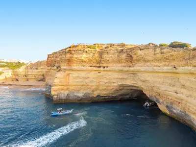 two boats in the water next to a large cliff at Villa Saint Martin by Algarve Vacation in Albufeira