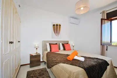 a bedroom with a large bed with orange pillows at Villa Zanzibar by Algarve Vacation in Olhos de Água