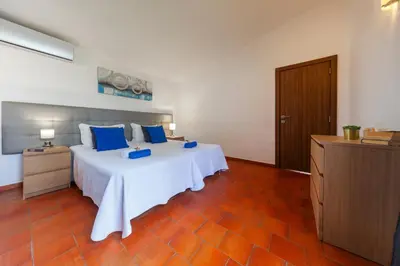 a bedroom with a large white bed with blue pillows at Villa Kailua by Algarve Vacation in Albufeira