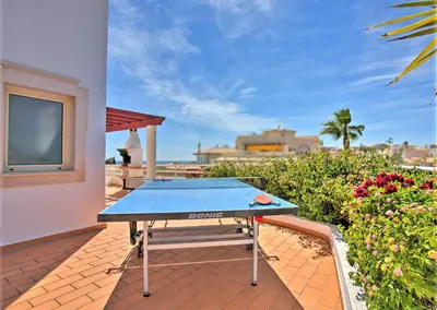 a ping pong table on the patio of a house at Villa Melanésia by Algarve Vacation in Guia