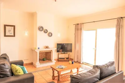a living room with a couch and a tv at Villa Melanésia by Algarve Vacation in Guia