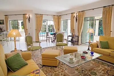 a living room with yellow furniture and a table at Villa Tulum by Algarve Vacation in Almancil