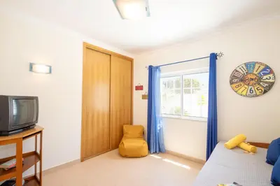 a living room with a tv and a yellow chair at Villa Manihi by Algarve Vacation in Albufeira