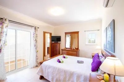 a bedroom with a white bed and a window at Villa Manihi by Algarve Vacation in Albufeira