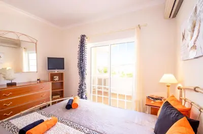 a bedroom with a bed with a dresser and a window at Villa Manihi by Algarve Vacation in Albufeira