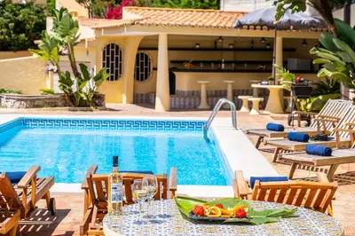 a table with a bowl of fruit next to a swimming pool at Villa Crisandra by Algarve Vacation in Albufeira