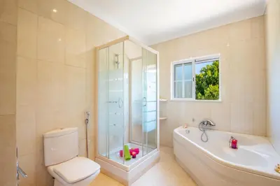 a bathroom with a shower and a toilet and a tub at Villa Savannah by Algarve Vacation in Almancil