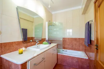 a bathroom with a sink and a tub and a mirror at Villa Savannah by Algarve Vacation in Almancil