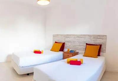 two beds with colorful pillows in a room at Villa Turtle Beach by Algarve Vacation in Albufeira