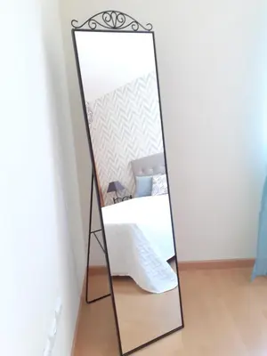 a mirror with a black frame in a bedroom at Apartamento Alfarrobeira Mar in Quarteira