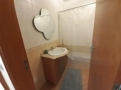 a bathroom with a sink and a mirror on the wall at Apartamento Alfarrobeira Mar in Quarteira