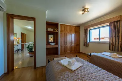 a bedroom with two beds and a large window at Villa with Garden and Pool in Vilamoura
