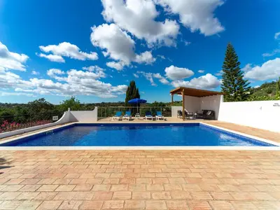 a swimming pool in a villa with a blue sky at Casa O Sonho near Faro with private pool in Santa Bárbara de Nexe