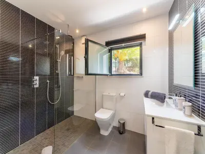 a bathroom with a toilet and a glass shower at Casa O Sonho near Faro with private pool in Santa Bárbara de Nexe