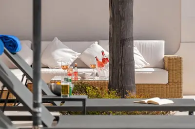 a living room with a couch and a table with wine glasses at Villa Coral - Varandas do Lago in Almancil