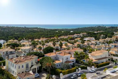 an aerial view of a town with houses and the ocean at Villa Coral - Varandas do Lago in Almancil