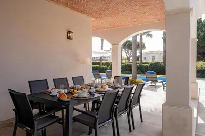 a black table and chairs in a patio at Villa Coral - Varandas do Lago in Almancil