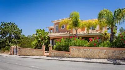 a house with a fence and flowers on a street at Villa Natura - Varandas do Lago in Almancil