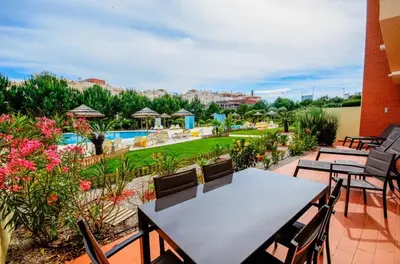 a patio with tables and chairs and a pool at Casa Sol Corcovada in Albufeira