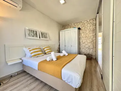 a bedroom with a large bed and a stone wall at Albufeira Delight with Pool by Homing in Guia