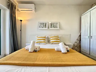 a bedroom with a large bed with yellow and white pillows at Albufeira Delight with Pool by Homing in Guia