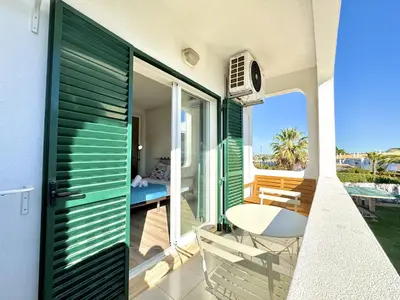 a room with a balcony with a table and chairs at Albufeira Delight with Pool by Homing in Guia