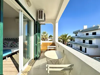 a balcony with a table and a bed on it at Albufeira Delight with Pool by Homing in Guia
