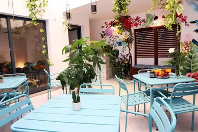 a patio with blue tables and chairs and a plant at Le Jardin Secret de Faro Guesthouse in Faro