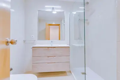 a white bedroom with a bed and a large window at Tália - City Center - Vilamoura in Vilamoura