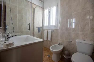 a white bathroom with a toilet and a sink at T2 Apartamento do Tenis in Albufeira