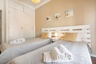 two beds in a bedroom with towels on them at T2 Apartamento do Tenis in Albufeira
