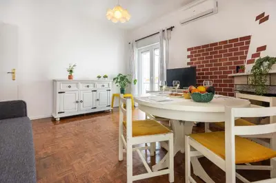 a kitchen and dining room with a white table and chairs at T2 Apartamento do Tenis in Albufeira