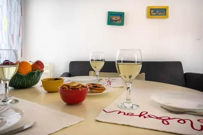 a table with two glasses of white wine on it at T2 Apartamento do Tenis in Albufeira