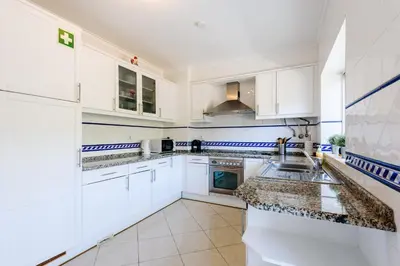 a white kitchen with white cabinets and a sink at Amazing apartment in Albufeira in Albufeira