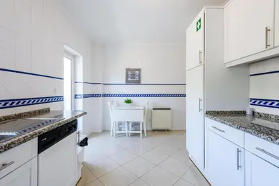 a kitchen with white cabinets and a table in it at Amazing apartment in Albufeira in Albufeira