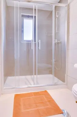 a shower with a glass door in a bathroom at Cruzeiro do Sul Apartments - Vilamoura center in Vilamoura