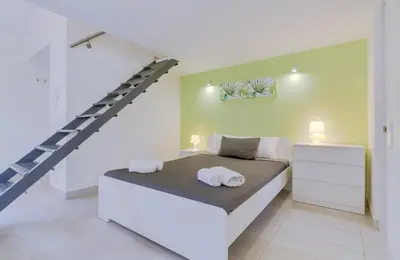 a bedroom with a bed with a staircase in it at Cruzeiro do Sul Apartments - Vilamoura center in Vilamoura