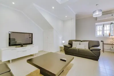 a living room with a couch and a tv at Faro Tradicional House - City center in Faro