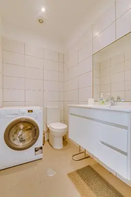 a bathroom with a washing machine and a toilet at Faro Tradicional House - City center in Faro