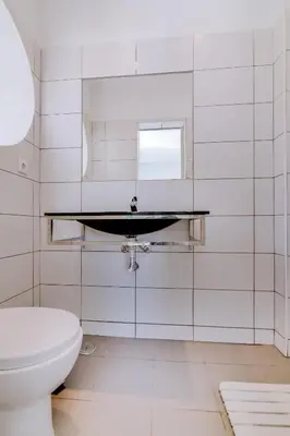 a white bathroom with a sink and a toilet at Faro Tradicional House - City center in Faro